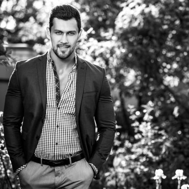 Klasik ceketli zarif yakışıklı adamı açık poz veriyor