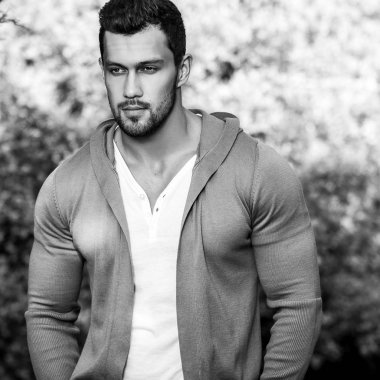 Siyah-beyaz açık doğa arka plan karşı rahat kıyafetler sportif yakışıklı adam portresi.