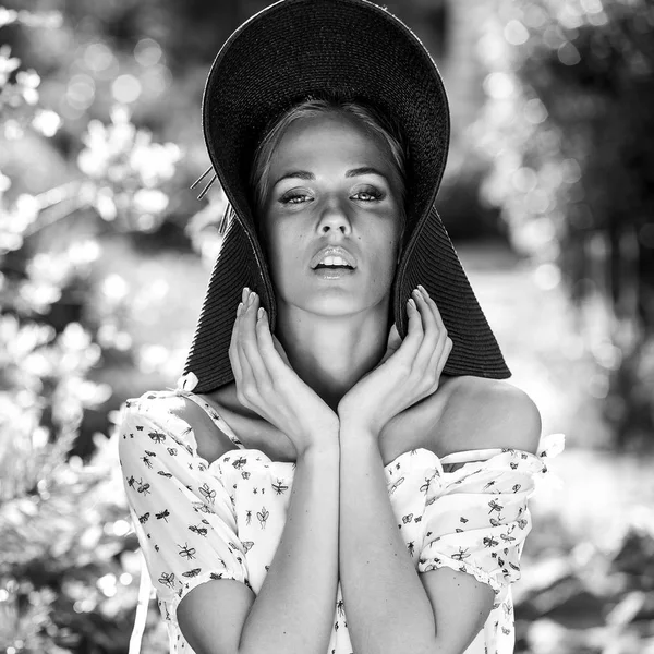 Black-white outdoor portrait of beautiful young blonde sexy woman in black classic hat. — Stock Photo, Image