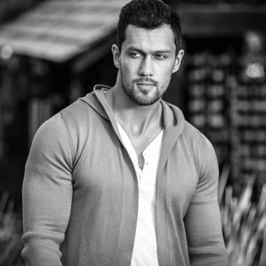 Siyah-beyaz açık doğa arka plan karşı rahat kıyafetler sportif yakışıklı adam portresi.