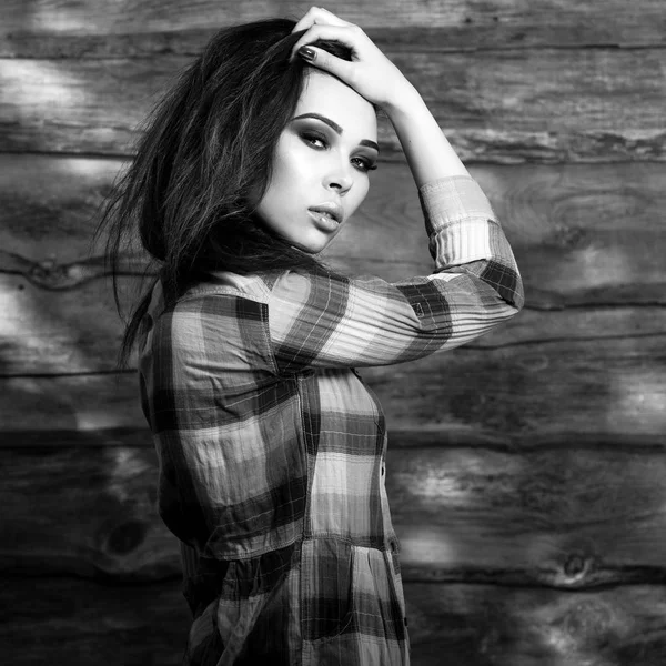 Jeune femme brune sensuelle et beauté pose sur un fond en bois. Photo noir-blanc . — Photo