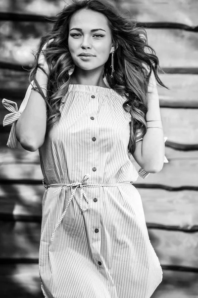 Młody zmysłowy & piękna dziewczyna w stylowy sukienka stanowią drewniane tle nieczysty. Fotografia czarno biała. — Zdjęcie stockowe