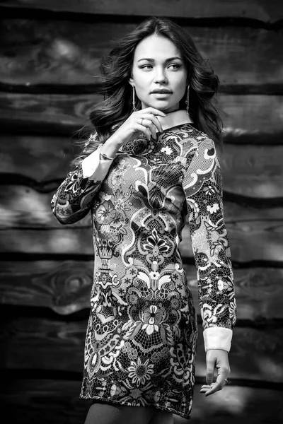 Молода чуттєва і красива дівчина в стильній сукні позує на дерев'яному тлі. Чорно-біле фото . — стокове фото
