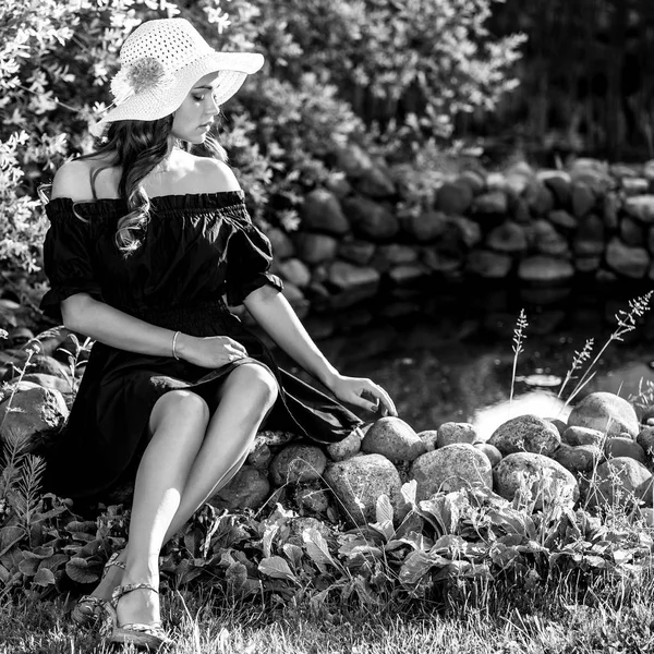 Schwarz-weißes Outdoor-Porträt einer schönen jungen Frau mit klassischem Hut. — Stockfoto