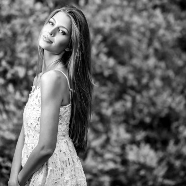 Siyah-beyaz açık havada güzel genç sarışın bir kadın portresi.