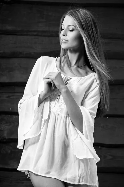 官能的なヤング ・美容金髪女性は、木製の背景にポーズします。白黒写真. — ストック写真