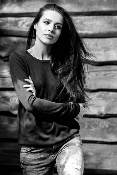 Junge sinnliche und schöne brünette Frau posiert auf hölzernem Hintergrund. Schwarz-Weiß-Foto. — Stockfoto