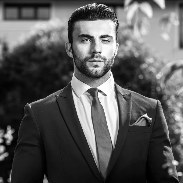 Retrato al aire libre blanco y negro de un hombre guapo elegante en traje clásico . — Foto de Stock