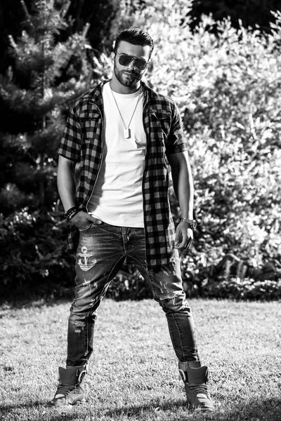 Retrato al aire libre blanco y negro de un hombre guapo con estilo deportivo en ropa casual . — Foto de Stock