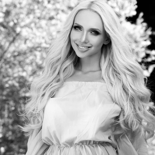 Svart-vit utomhus porträtt av vacker ung blond kvinna i snygg klänning. — Stockfoto
