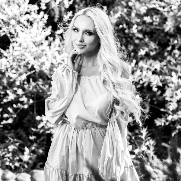 Retrato al aire libre blanco y negro de una hermosa mujer rubia joven en vestido elegante . — Foto de Stock