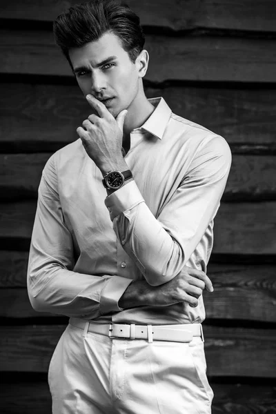 Czarno biały portret przystojny modny młodzieniec drewnianą ścianę. — Zdjęcie stockowe