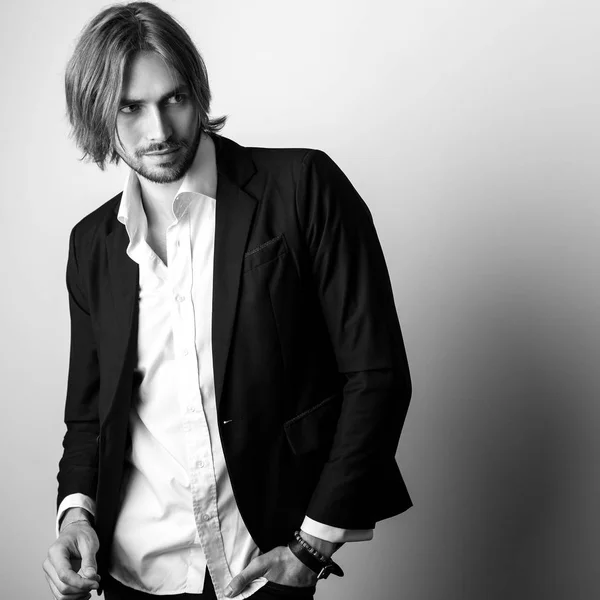 Black-white portrait of young handsome long hair man against studio background. — Stock Photo, Image