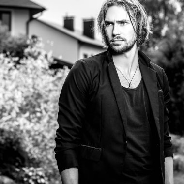 Siyah-beyaz açık zarif uzun saçlı yakışıklı adam portresi.