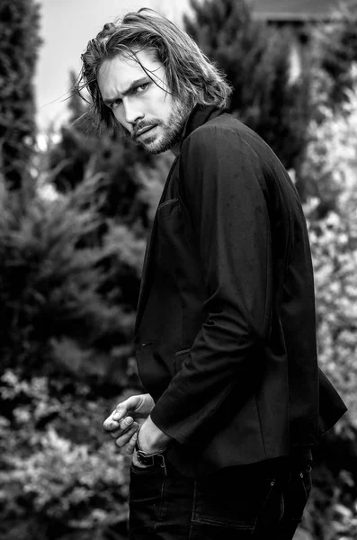 Ritratto all'aperto in bianco-nero di elegante uomo bello capelli lunghi . — Foto Stock