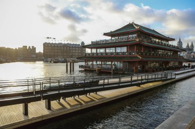 Amsterdam, Hollanda - 28 Aralık 2016: Ünlü binalar ve güneş, Amsterdam şehir merkezinin yer saatini ayarlayın. Genel manzara görünümü. 28 Aralık 2016 - Amsterdam - Hollanda