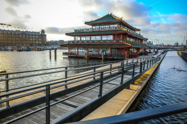 Amsterdam, Hollanda - 28 Aralık 2016: Ünlü binalar ve güneş, Amsterdam şehir merkezinin yer saatini ayarlayın. Genel manzara görünümü. 28 Aralık 2016 - Amsterdam - Hollanda