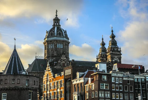 AMSTERDAM, NETHERLANDS - DECEMBER 28, 2016: Famous buildings and place of Amsterdam city centre at sun set time. General landscape view. December 28, 2016 - Amsterdam - Netherlands — Stock Photo, Image