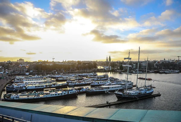 AMESTERDÃO, PAÍSES BAIXOS - JANEIRO 02, 2017: Barcos na água em belo pôr-do-sol da noite. 02 de janeiro de 2017 em Amsterdam - Países Baixos . — Fotografia de Stock