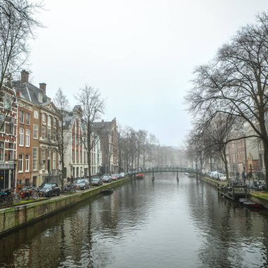 Amsterdam, Hollanda - 28 Aralık 2016: Ünlü binalar ve güneş, Amsterdam şehir merkezinin yer saatini ayarlayın. Genel manzara görünümü. 28 Aralık 2016 - Amsterdam - Hollanda