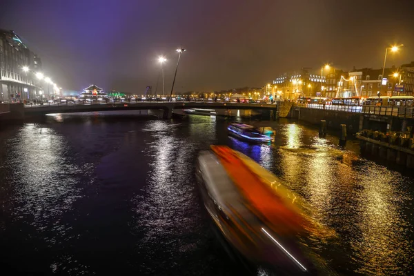 AMSTERDAM, PAÍSES BAJOS - 02 DE ENERO DE 2017: Crucero por los canales nocturnos de Ámsterdam. Enero 02, 2017 en Amsterdam - Holanda . — Foto de Stock