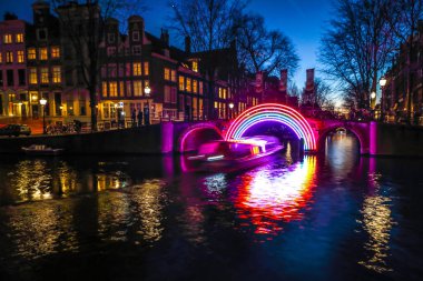 Amsterdam, Hollanda - 10 Ocak 2017: Cruise tekneler acele gece kanallarında. Amsterdam içinde ışık Festivali ışık teçhizatları gece Kanallar üzerinde. 10 Ocak 2017 yılında Amsterdam - Hollanda.