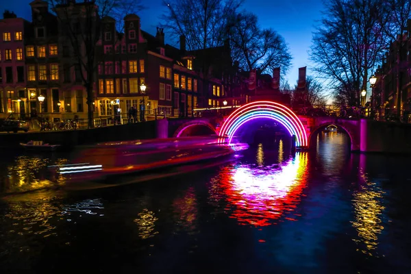 Amsterdam, Hollanda - 10 Ocak 2017: Cruise tekneler acele gece kanallarında. Amsterdam içinde ışık Festivali ışık teçhizatları gece Kanallar üzerinde. 10 Ocak 2017 yılında Amsterdam - Hollanda.