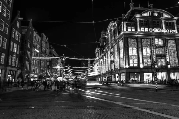 AMSTERDAM, PAÍSES BAJOS - 08 DE ENERO DE 2017: Amsterdam calles nocturnas de la ciudad con diferentes tipos de transporte en movimiento y siluetas de transeúntes. enero 08, 2017 en Amsterdam - Países Bajos . — Foto de Stock