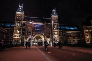 Amsterdam, Hollanda - 07 Ocak 2017: Hareketli siluetleri bisikletçiler ve Rijksmuseum (Ulusal Müzesi sanat ve Tarih için adanmış) yakınındaki geçenler. 07 Ocak 2017 Amsterdam, Hollanda.