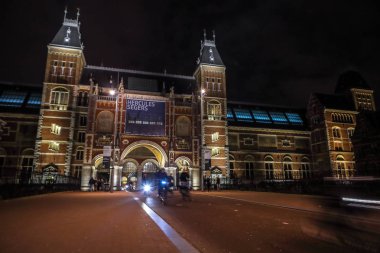 Amsterdam, Hollanda - 07 Ocak 2017: Hareketli siluetleri bisikletçiler ve Rijksmuseum (Ulusal Müzesi sanat ve Tarih için adanmış) yakınındaki geçenler. 07 Ocak 2017 Amsterdam, Hollanda.