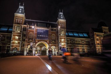 Amsterdam, Hollanda - 07 Ocak 2017: Hareketli siluetleri bisikletçiler ve Rijksmuseum (Ulusal Müzesi sanat ve Tarih için adanmış) yakınındaki geçenler. 07 Ocak 2017 Amsterdam, Hollanda.
