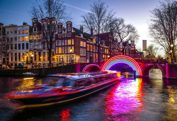 AMSTERDAM, PAYS-BAS - 10 JANVIER 2017 : Les bateaux de croisière se précipitent dans les canaux de nuit. Installations lumineuses sur les canaux nocturnes d'Amsterdam dans le cadre du Light Festival. 10 janvier 2017 à Amsterdam - Pays-Bas . — Photo