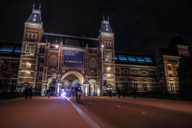 Amsterdam, Hollanda - 07 Ocak 2017: Hareketli siluetleri bisikletçiler ve Rijksmuseum (Ulusal Müzesi sanat ve Tarih için adanmış) yakınındaki geçenler. 07 Ocak 2017 Amsterdam, Hollanda.