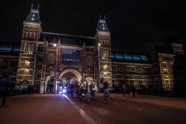 Amsterdam, Hollanda - 07 Ocak 2017: Hareketli siluetleri bisikletçiler ve Rijksmuseum (Ulusal Müzesi sanat ve Tarih için adanmış) yakınındaki geçenler. 07 Ocak 2017 Amsterdam, Hollanda.