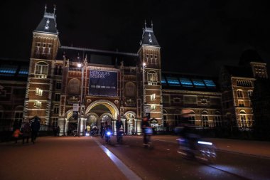 Amsterdam, Hollanda - 07 Ocak 2017: Hareketli siluetleri bisikletçiler ve Rijksmuseum (Ulusal Müzesi sanat ve Tarih için adanmış) yakınındaki geçenler. 07 Ocak 2017 Amsterdam, Hollanda.