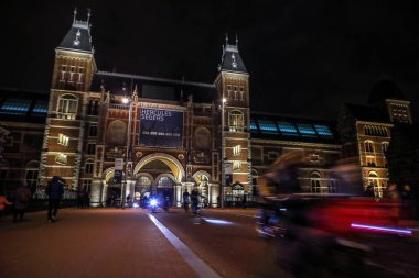 Amsterdam, Hollanda - 07 Ocak 2017: Hareketli siluetleri bisikletçiler ve Rijksmuseum (Ulusal Müzesi sanat ve Tarih için adanmış) yakınındaki geçenler. 07 Ocak 2017 Amsterdam, Hollanda.