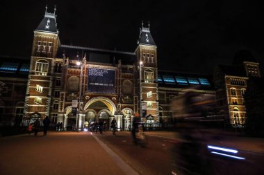 Amsterdam, Hollanda - 07 Ocak 2017: Hareketli siluetleri bisikletçiler ve Rijksmuseum (Ulusal Müzesi sanat ve Tarih için adanmış) yakınındaki geçenler. 07 Ocak 2017 Amsterdam, Hollanda.