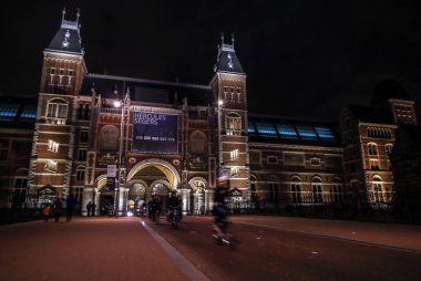 Amsterdam, Hollanda - 07 Ocak 2017: Hareketli siluetleri bisikletçiler ve Rijksmuseum (Ulusal Müzesi sanat ve Tarih için adanmış) yakınındaki geçenler. 07 Ocak 2017 Amsterdam, Hollanda.