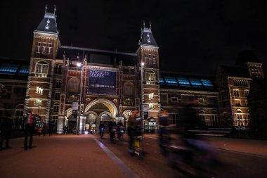 Amsterdam, Hollanda - 07 Ocak 2017: Hareketli siluetleri bisikletçiler ve Rijksmuseum (Ulusal Müzesi sanat ve Tarih için adanmış) yakınındaki geçenler. 07 Ocak 2017 Amsterdam, Hollanda.