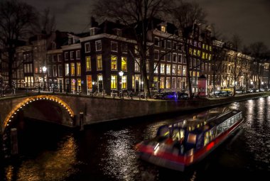 Amsterdam, Hollanda - 11 Ocak 2017: yolcu tekne hareket ile güzel bir gece şehir Amsterdam kanalları. 11 Ocak 2017 yılında Amsterdam - Hollanda.