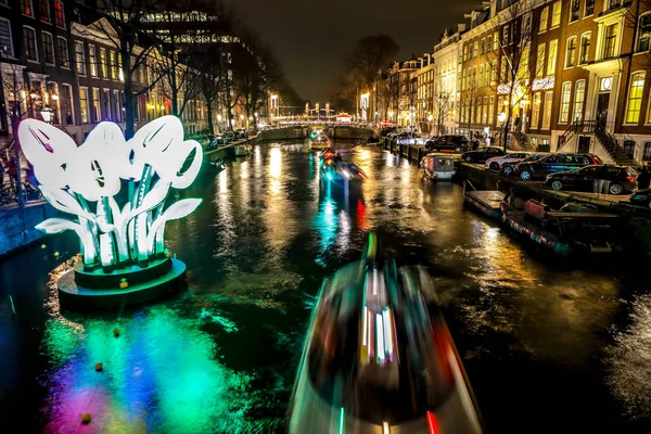 阿姆斯特丹，荷兰-2017 年 1 月 11 日︰ 巡航船冲在晚上运河。在夜晚运河阿姆斯特丹内光节日的灯光设施。2017 年 1 月 11 日在阿姆斯特丹-荷兰 — 图库照片