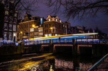Amsterdam, Hollanda - 08 Ocak 2017: Tramvaylar sürücüler tarafından gece Amsterdam şehir içinde eski köprü. 08 Ocak 2017 yılında Amsterdam - Hollanda.