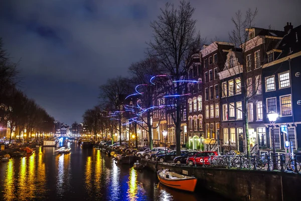 Amsterdam, Holandia - 12 stycznia 2017 roku: Piękna noc miasta kanałów w Amsterdamie z ruchomymi pasażera łódź. 12 stycznia 2017 roku w Amsterdam - Holandia. — Zdjęcie stockowe
