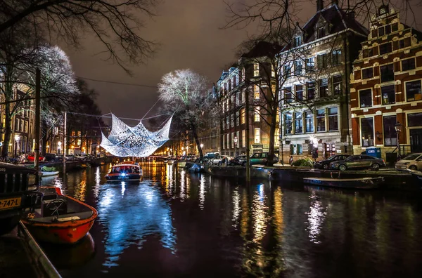 阿姆斯特丹，荷兰-2017 年 1 月 12 日︰ 巡航船冲在晚上运河。在夜晚运河阿姆斯特丹内光节日的灯光设施。2017 年 1 月 12 日在阿姆斯特丹-荷兰 — 图库照片