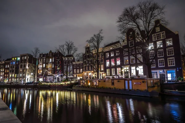 AMSTERDAM, PAÍSES BAJOS - 12 DE ENERO DE 2017: Hermosos canales nocturnos de Ámsterdam. 12 de enero de 2017 en Amsterdam - Países Bajos . — Foto de Stock