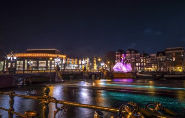 Amsterdam, Hollanda - 12 Ocak 2017: Cruise tekneler acele gece kanallarında. Amsterdam içinde ışık Festivali ışık teçhizatları gece Kanallar üzerinde. 12 Ocak 2017 yılında Amsterdam - Hollanda