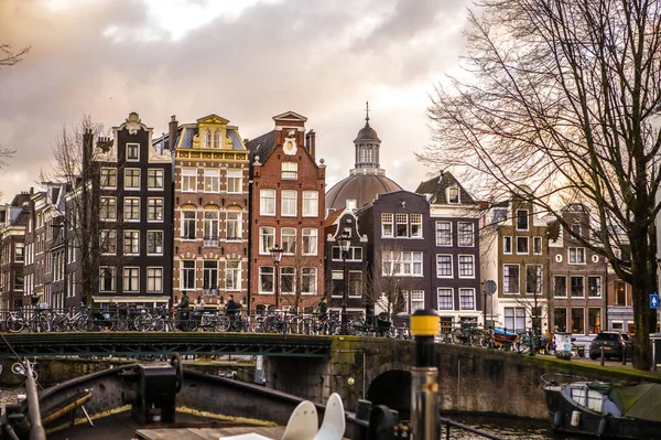 Amsterdam, Nizozemsko - 10 ledna 2017: Vintage a pamětihodnosti města Amsterdamu na západ slunce. Obecné krajiny pohled na tradici holandské arcitecture. 10. ledna 2017 - Amsterdam - Nizozemsko — Stock fotografie