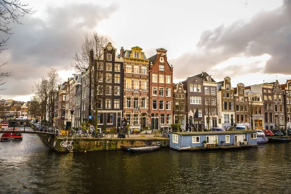 AMSTERDAM, PAESI BASSI - 10 GENNAIO 2017: Famosi edifici vintage e canali della città di Amsterdam al tramonto. Vista generale del paesaggio. gennaio 10, 2017 - Amsterdam - Paesi Bassi — Foto Stock