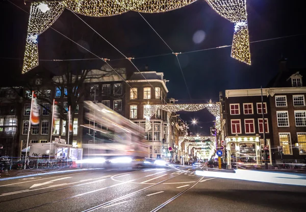 Amszterdam, Hollandia - 2017. január 11.: Fényszóró autó halad utcán, éjszaka. Idő telik el. Január 11-én, 2017-Amszterdam - Hollandia. — Stock Fotó