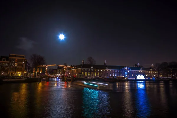 Amsterdam, Hollanda - 12 Ocak 2017: Cruise tekneler acele gece kanallarında. Dolunay Amsterdam ışık Festivali içinde ışık Installations gece Kanallar üzerinde. Amsterdam - Hollanda — Stok fotoğraf